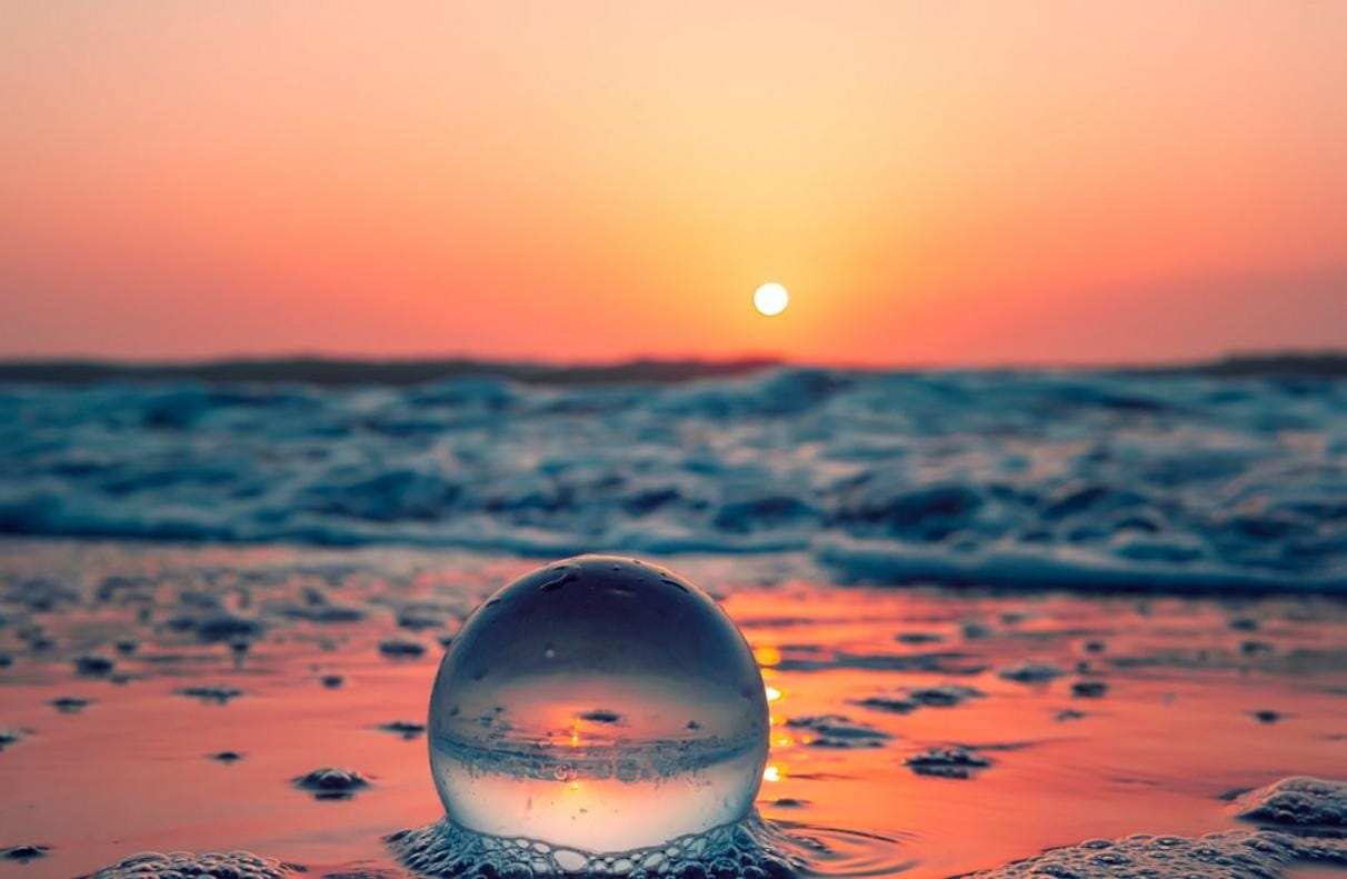 Bir kişinin rahatlatıcı ses terapisi ve meditasyon yaparken huzur içerisinde olduğunu gösteren, doğayla iç içe bir ortamda görüntü
