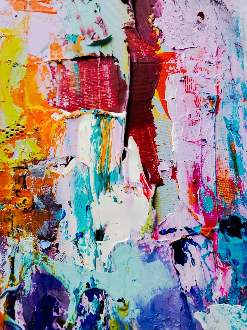Modern sanat eserlerinin sergilendiği, renklerin ve dokuların iç içe geçtiği geniş bir galeri alanı